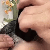 Person applying product to hair with a brush